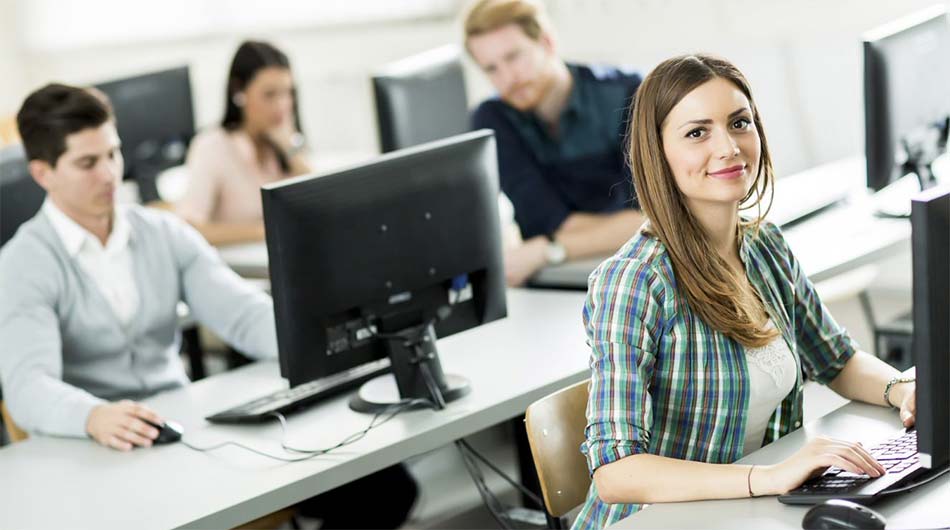 Auf diesem Bild sieht man eine Schulungsteilnehmerin an einem Desktop-PC, in einem Schulungsraum der GFN. Im Hintergrund sind weitere Schulungsteilnehmende zu erkennen.
