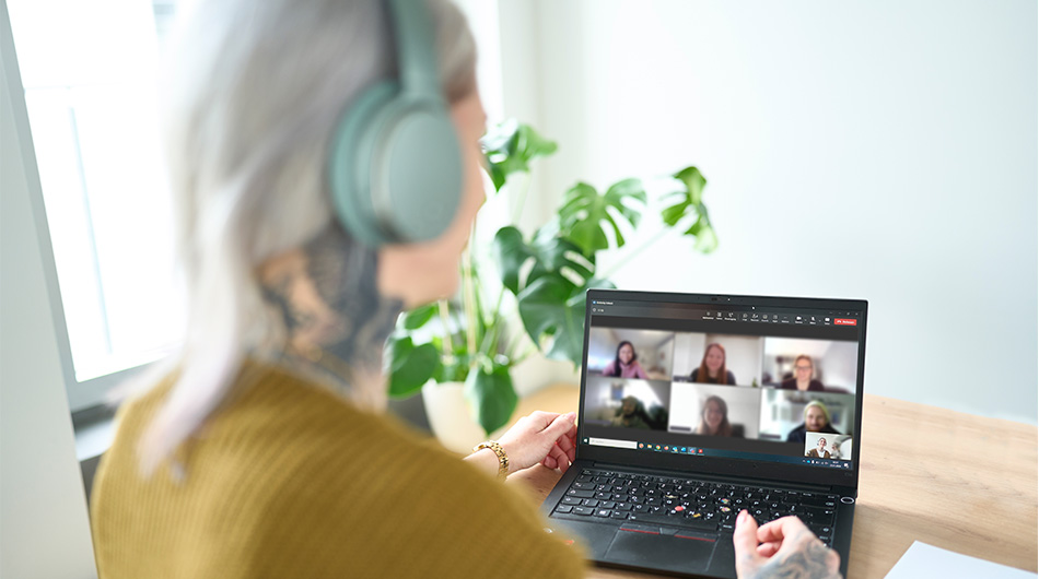 Zu sehen ist eine Weiterbildungs-Teilnehmerin in ihrer Online Weiterbildung, auf dem Bildschrim sind weitere Teilnehmer vom Kurs zu sehen.